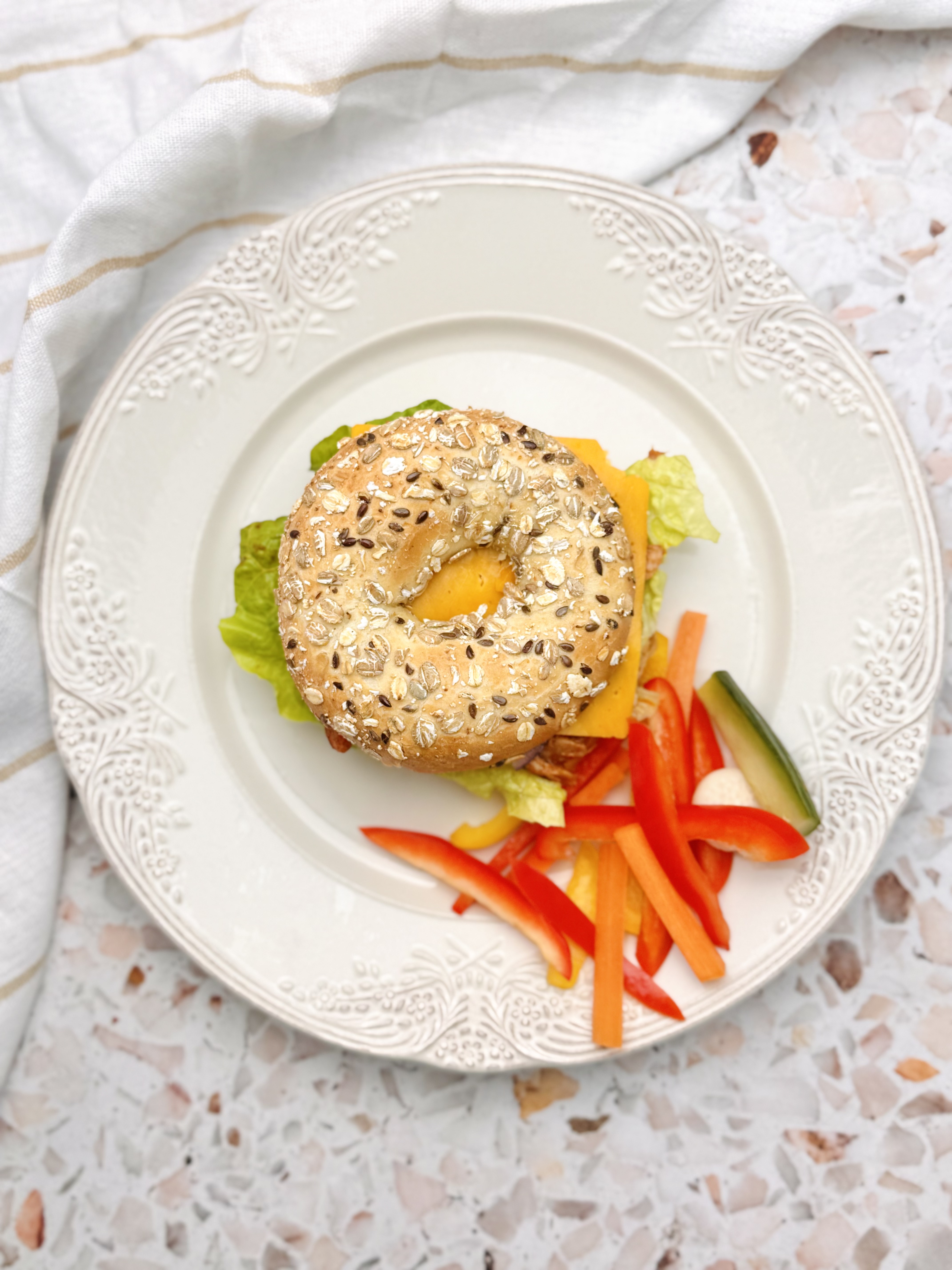 Bajgiel wieloziarnisty z szarpanym tofu w domowym sosie bbq i serem cheddar / chrupiące warzywa