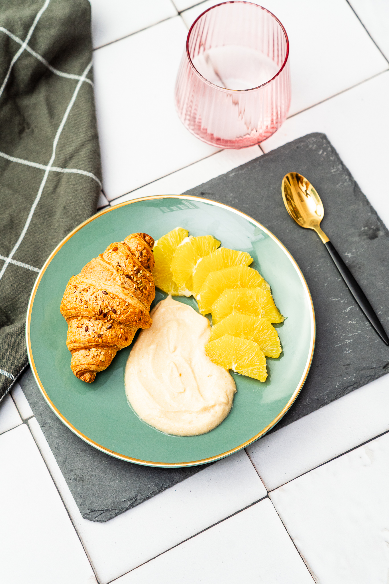 Crossiant pełnoziarnisty z ricottą i dżemem podany ze świeżą pomarańczą