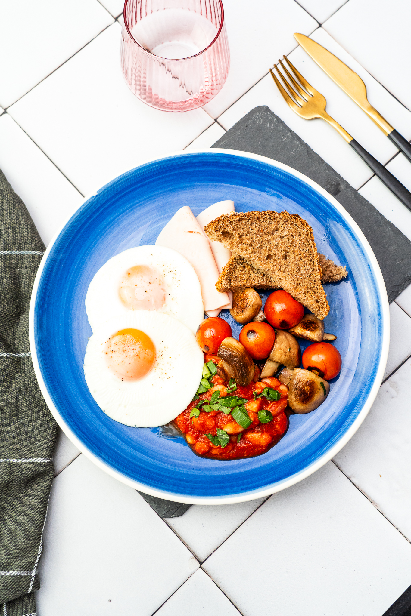 Śniadanie w stylu angielskim z sadzonym jajkiem, szynką drobiową, fasolką w sosie pomidorowym