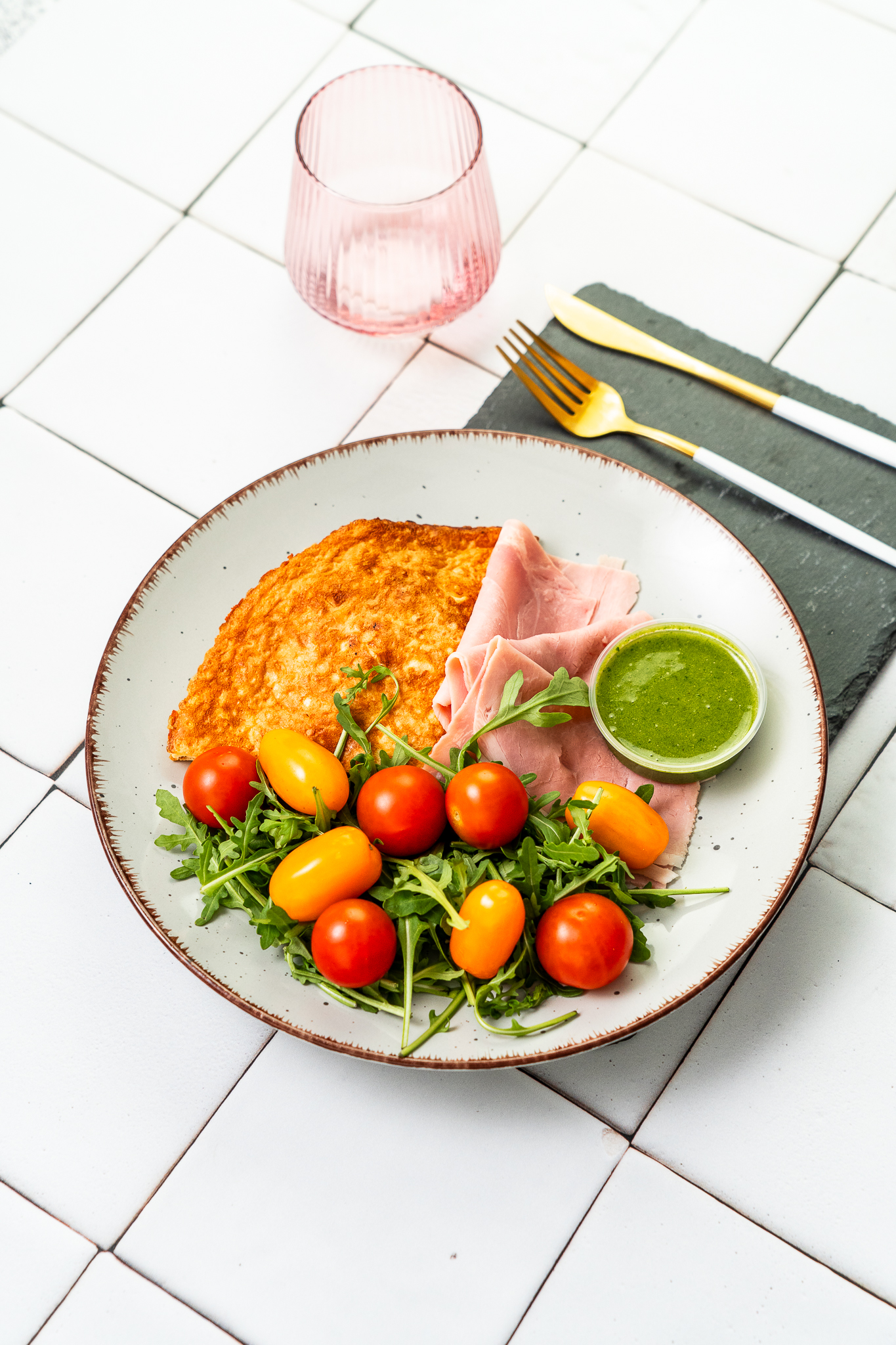 Omlet francuski z parmezanem, solą morską i świeżo mielonym pieprzem podany z pesto i szynką cotto
