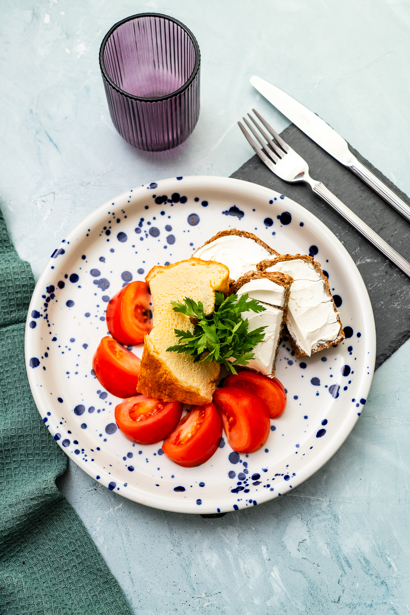 Omlet francuski podany z pieczywem żytnim na zakwasie z serkiem śmietankowym, awokado, rukolą i pomidorem malinowym