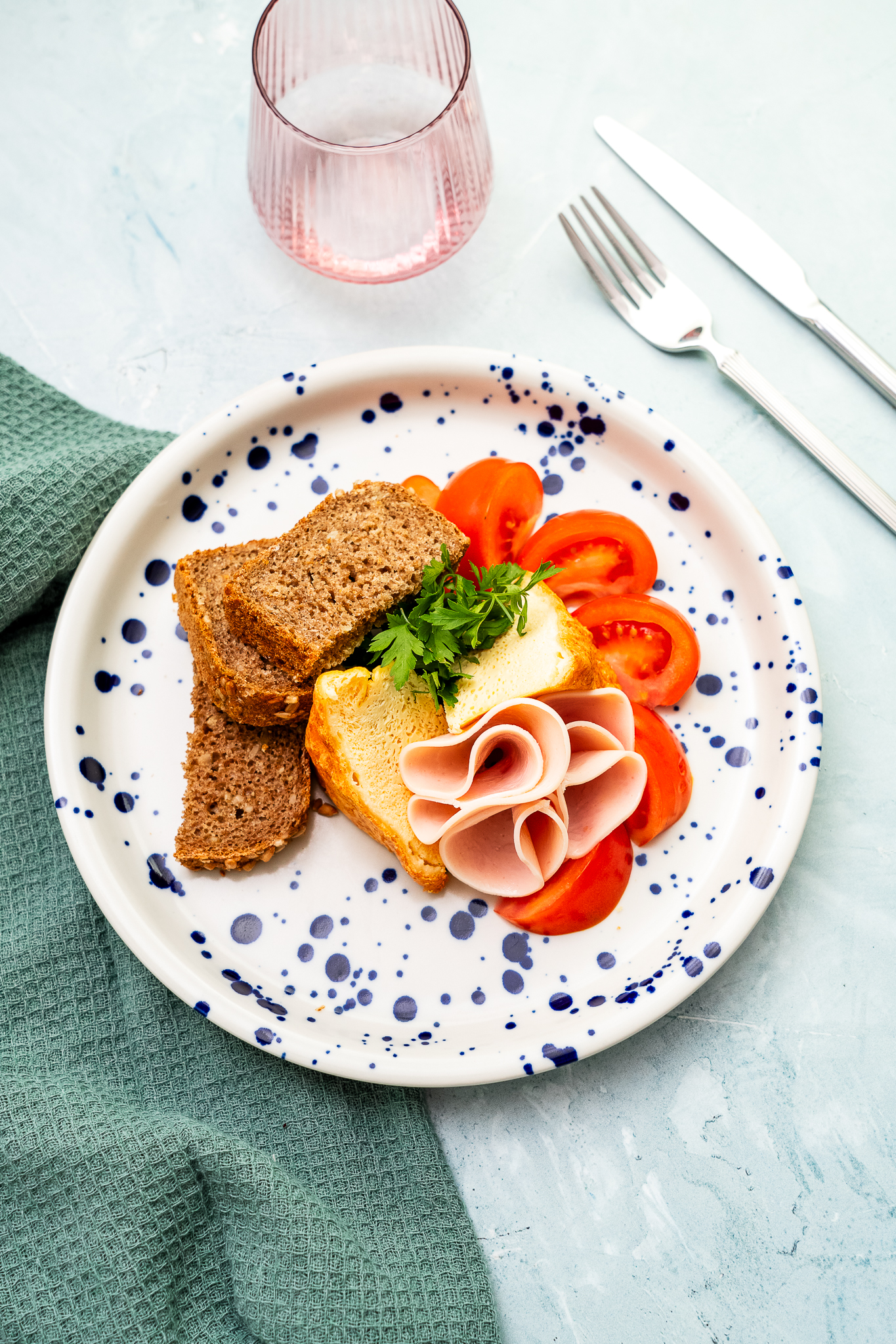 Omlet francuski podany z pieczywem żytnim na zakwasie, szynką drobiową, rukolą i pomidorem malinowym