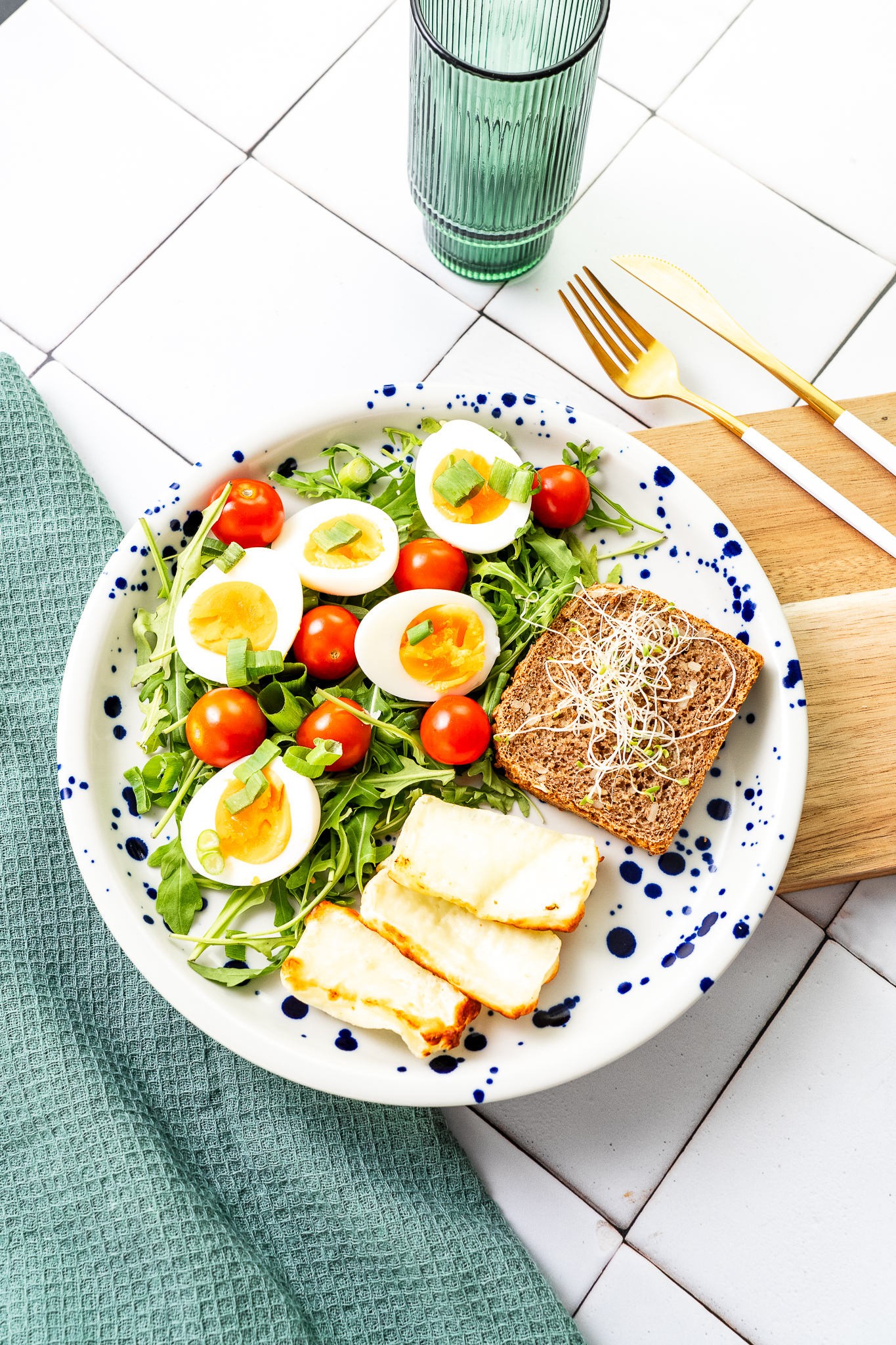 Jajka na miękko z halloumi, pomidorkiem cherry, rukolą podane z pieczywem żytnim na zakwasie