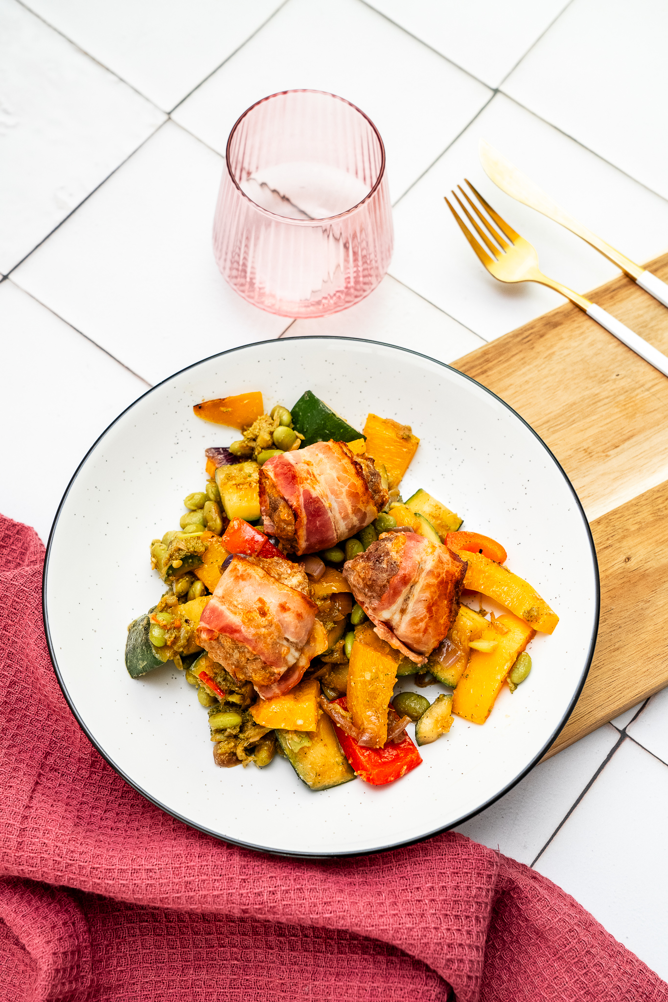 Klopsiki keto wieprzowo-wołowe zawijane w boczku podane z duszonymi na oliwie warzywami z edamame