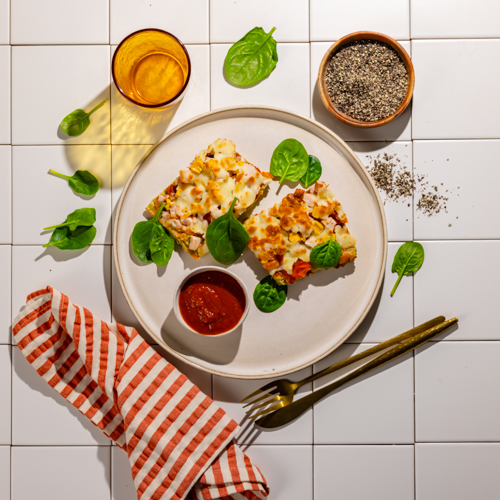 Pizza na zielonym spodzie warzywnym z kukurydzą, pomidorami i szynką z indyka